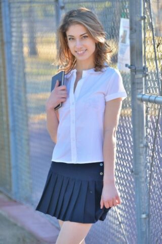 Thin teen shows off her upskirt panties in her schoolgirl uniform on sidewalk