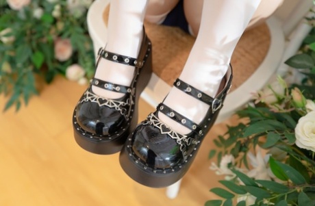 Adorable Japanese girl removes her shoes while wearing white stockings