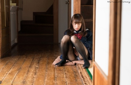 Young Asian schoolgirl pulling down her black pantyhose to masturbate