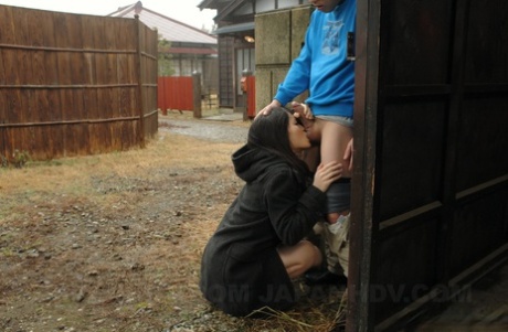 Asian honey Mai Shimizu kneels in front of a guy and gives head outdoors