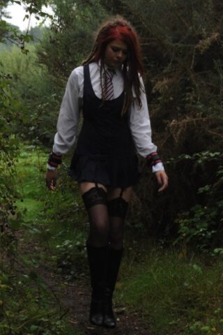Tall schoolgirl shows off her hot legs in stockings and boots outdoors