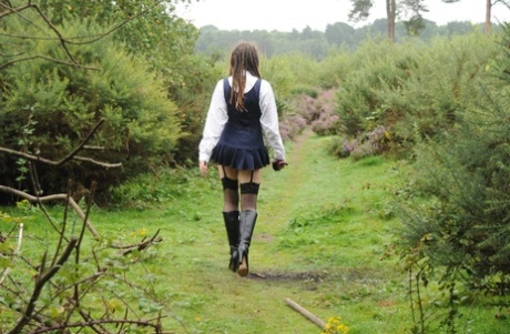 Tall schoolgirl shows off her hot legs in stockings and boots outdoors