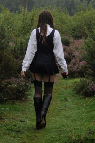 Tall schoolgirl shows off her hot legs in stockings and boots outdoors