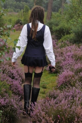 Tall schoolgirl shows off her hot legs in stockings and boots outdoors