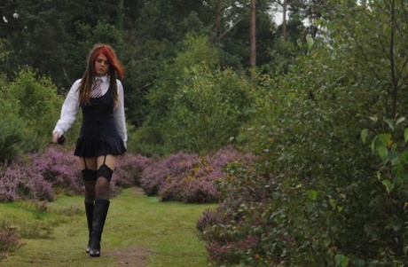 Tall schoolgirl shows off her hot legs in stockings and boots outdoors