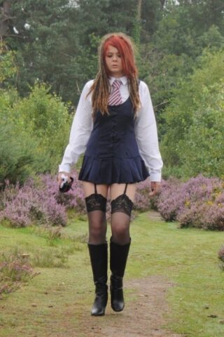 Tall schoolgirl shows off her hot legs in stockings and boots outdoors