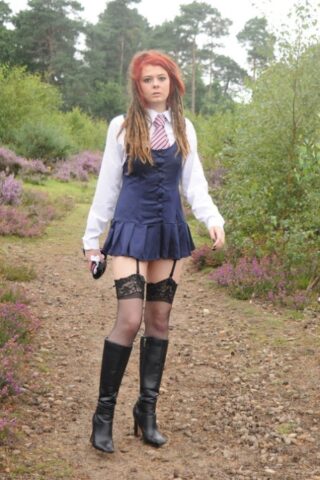 Tall schoolgirl shows off her hot legs in stockings and boots outdoors