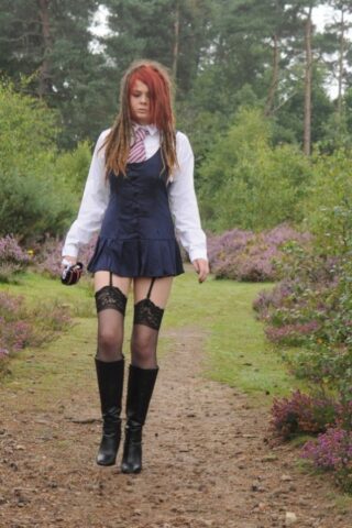 Tall schoolgirl shows off her hot legs in stockings and boots outdoors