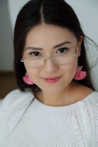 Adorable teen Kimiko unveils her cute breasts and shaved vagina on a bed