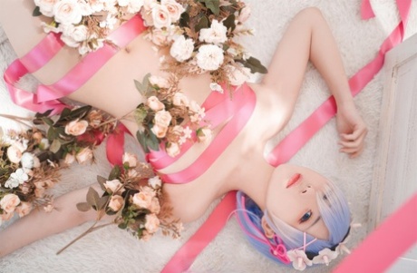 Beautiful Asian model with big tits poses while wrapped in pink satin ribbon
